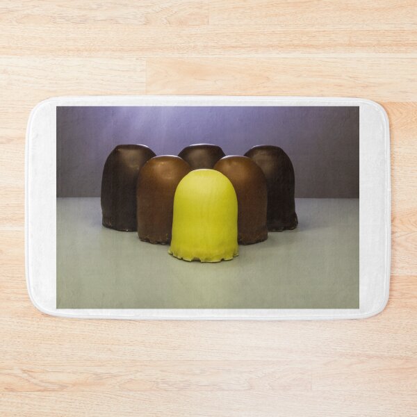 Item preview, Yellow Candy Standing Out Among Chocolate-Coated Confections On Gray Surface With Soft Lighting designed and sold by Nmallia.