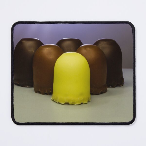 Item preview, Yellow Candy Standing Out Among Chocolate-Coated Confections On Gray Surface With Soft Lighting designed and sold by Nmallia.
