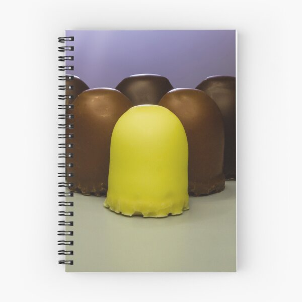 Item preview, Yellow Candy Standing Out Among Chocolate-Coated Confections On Gray Surface With Soft Lighting designed and sold by Nmallia.