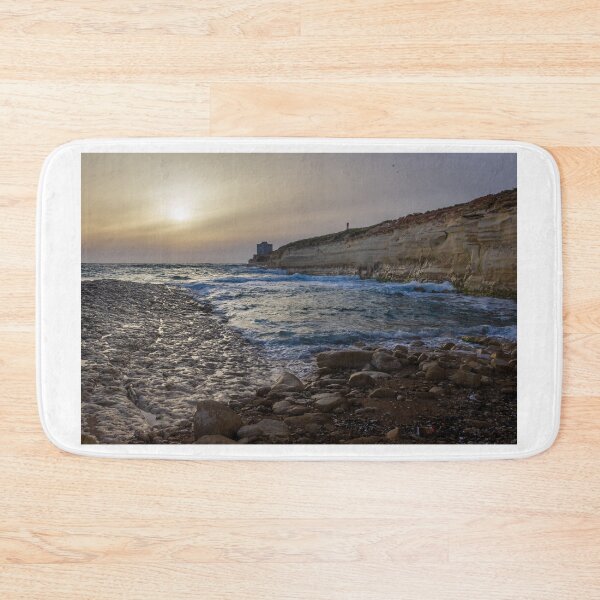 Item preview, Sunset Over Rocky Coastline With Waves, Cliff Fort And Distant Lighthouse On Calm Sea designed and sold by Nmallia.