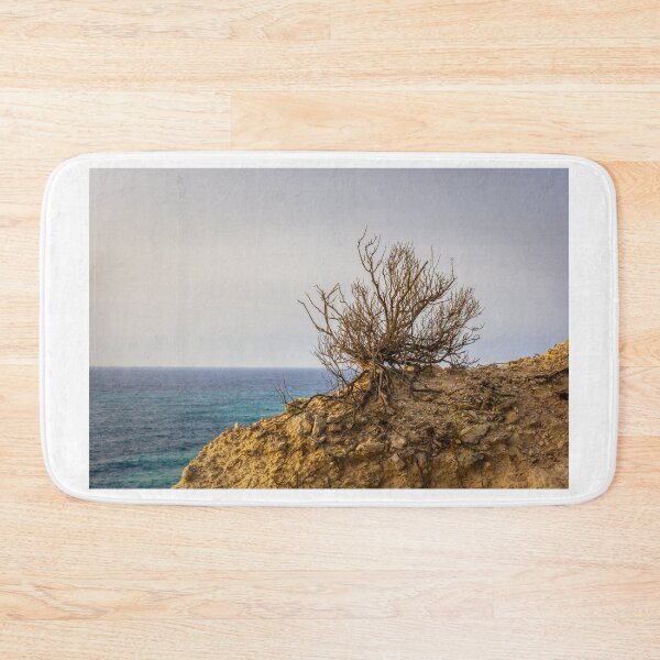 Item preview, Lonely Coastal Shrub Clinging to Rocky Cliff Overlooking Turquoise Sea at Sunset designed and sold by Nmallia.