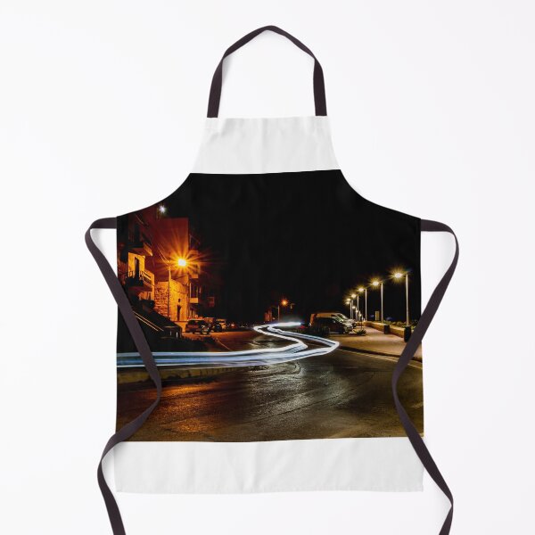 Item preview, Long Exposure Light Trails On Coastal Night Street With Lamp Posts And Parked Cars designed and sold by Nmallia.