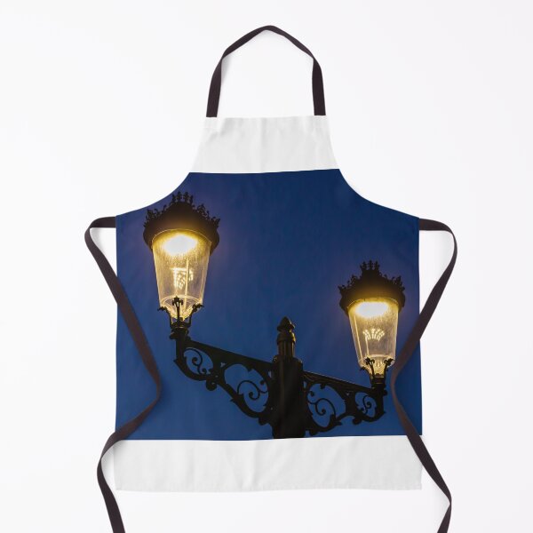 Item preview, Ornate Vintage Double Street Lamp Glowing at Dusk Against Deep Blue Evening Sky designed and sold by Nmallia.