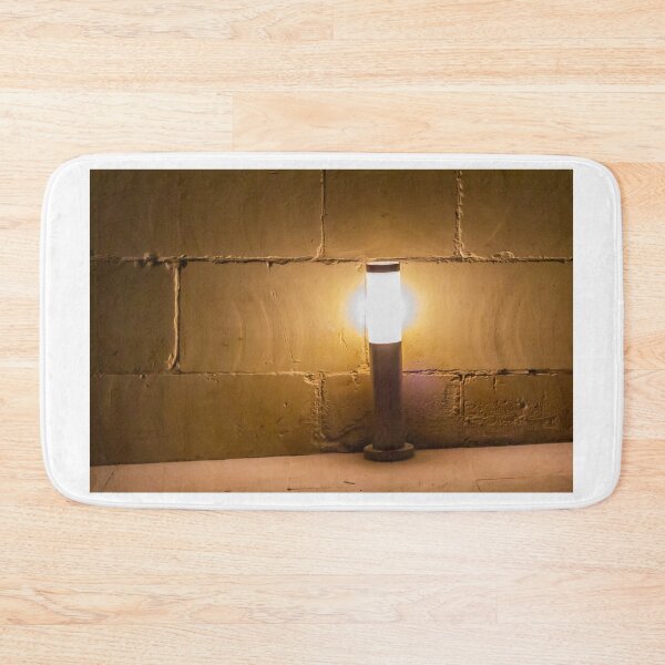 Item preview, Warm Outdoor Bollard Light Casting Soft Glow Against Textured Brick Wall At Night designed and sold by Nmallia.
