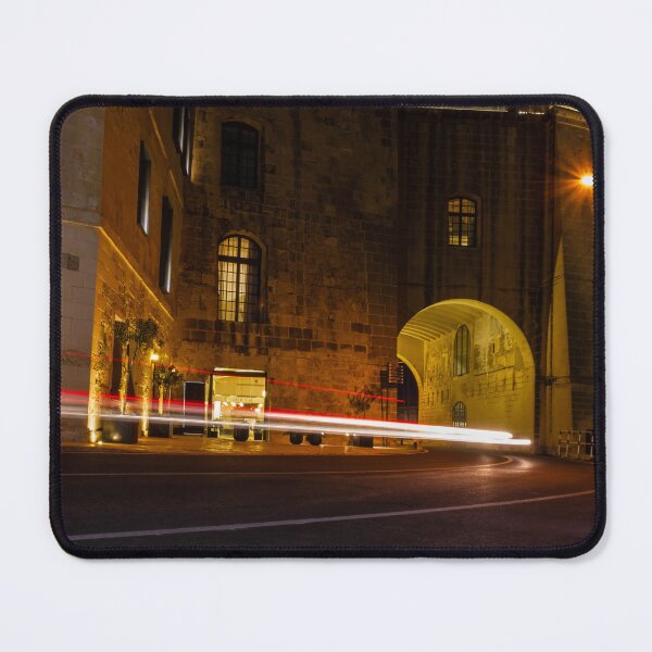 Item preview, Night Light Trails Through Historic Stone Archway On Curved Urban Street Under Warm Lighting designed and sold by Nmallia.