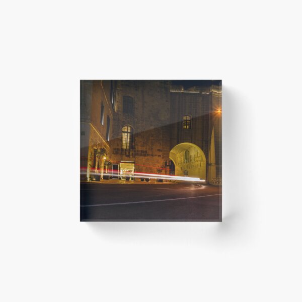 Item preview, Night Light Trails Through Historic Stone Archway On Curved Urban Street Under Warm Lighting designed and sold by Nmallia.