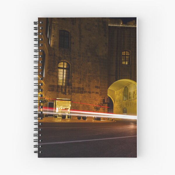 Item preview, Night Light Trails Through Historic Stone Archway On Curved Urban Street Under Warm Lighting designed and sold by Nmallia.