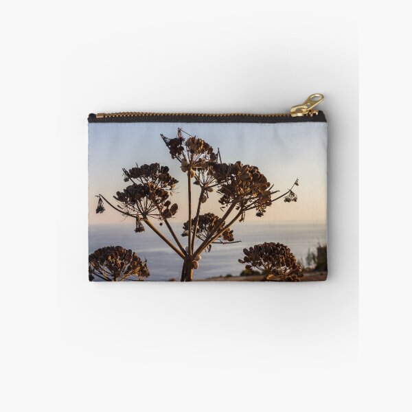 Item preview, Dried Umbel Seedheads Silhouette at Sunset Over Calm Coastal Sea and Rocky Shoreline designed and sold by Nmallia.
