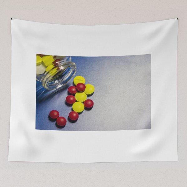 Item preview, Colorful Candy Tablets Spilling From Small Glass Jar On Blue Surface Background designed and sold by Nmallia.