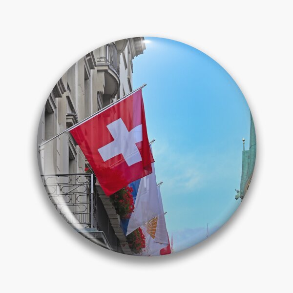 Item preview, A building with a Swiss flag and Grossmunster and Fraumunster church clock towers in the background, Zurich, Switzerland designed and sold by goceris.