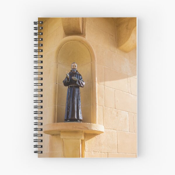 Item preview, Saint Statue In Church Niche On Stone Wall Evoking Faith And Quiet Devotion In Sunlight designed and sold by Nmallia.
