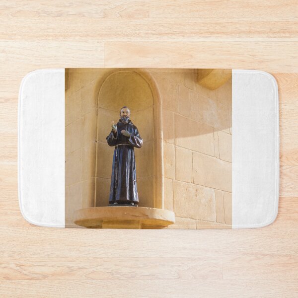 Item preview, Saint Statue In Church Niche On Stone Wall Evoking Faith And Quiet Devotion In Sunlight designed and sold by Nmallia.