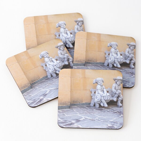 Item preview, Two Child Statues Sitting on a Bench Against a Rustic Wall in a Sunny Courtyard designed and sold by Nmallia.