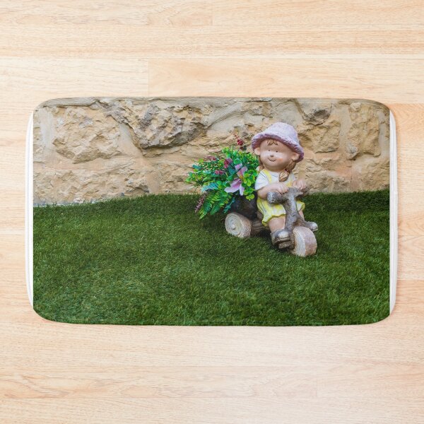 Item preview, Whimsical Garden Figurine Of Girl On Wooden Tricycle With Flowers Against Stone Wall designed and sold by Nmallia.