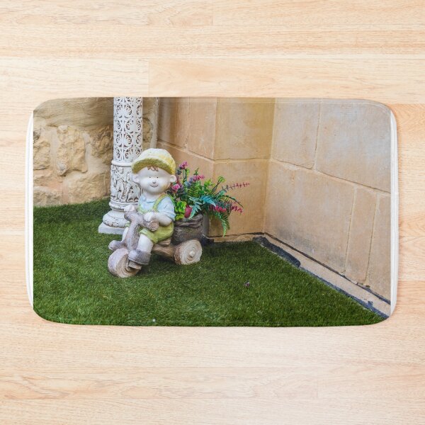 Item preview, Whimsical Garden Figurine Of Girl On Wooden Tricycle With Flowers Against Stone Wall designed and sold by Nmallia.