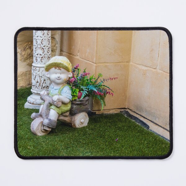 Item preview, Whimsical Garden Figurine Of Girl On Wooden Tricycle With Flowers Against Stone Wall designed and sold by Nmallia.