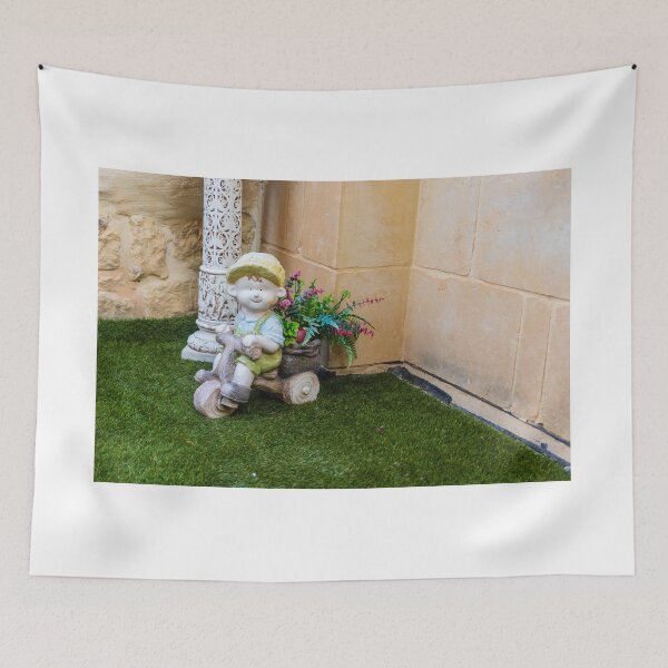 Item preview, Whimsical Garden Figurine Of Girl On Wooden Tricycle With Flowers Against Stone Wall designed and sold by Nmallia.