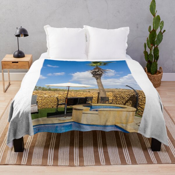 Item preview, Sunny Resort Pool With Palm Tree, Umbrella and Lounge Chairs Overlooking Stone Wall and Blue Sky designed and sold by Nmallia.