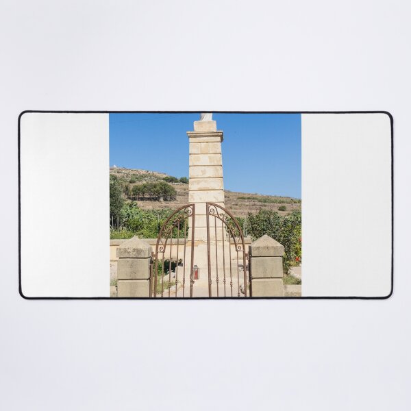 Item preview, Stone Madonna Statue on Pillar Behind Wrought Iron Gate at Rural Shrine Under Blue Sky designed and sold by Nmallia.