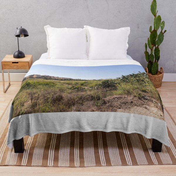 Item preview, Prickly Pear Cactus in Sunny Dry Field Near Low-Rise Town Buildings Under Clear Blue Sky designed and sold by Nmallia.