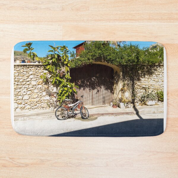 Item preview, Old Bicycle Leaning Against Stone Wall Near Wooden Gate with Potted Plants in Sunny Courtyard designed and sold by Nmallia.