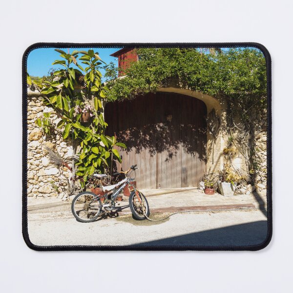 Item preview, Old Bicycle Leaning Against Stone Wall Near Wooden Gate with Potted Plants in Sunny Courtyard designed and sold by Nmallia.