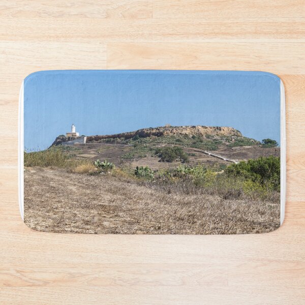 Item preview, White Lighthouse on Arid Coastal Hill Overlooking Dry Landscape and Blue Sky designed and sold by Nmallia.