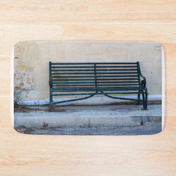 Item preview, Weathered Green Bench Against Aged Wall On Quiet Urban Sidewalk designed and sold by Nmallia.