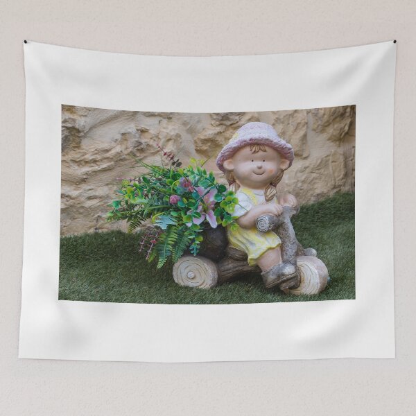 Item preview, Whimsical Garden Figurine Of Girl On Wooden Tricycle With Flowers Against Stone Wall designed and sold by Nmallia.