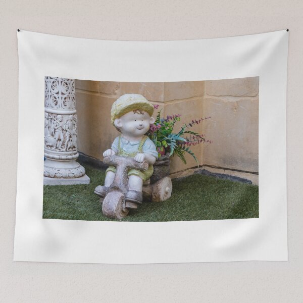 Item preview, Whimsical Garden Figurine Of Girl On Wooden Tricycle With Flowers Against Stone Wall designed and sold by Nmallia.