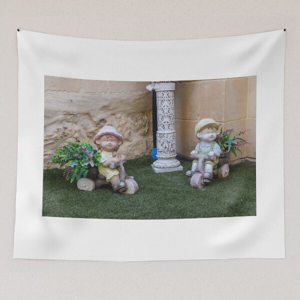 Item preview, Whimsical Garden Figurine Of Girl On Wooden Tricycle With Flowers Against Stone Wall designed and sold by Nmallia.