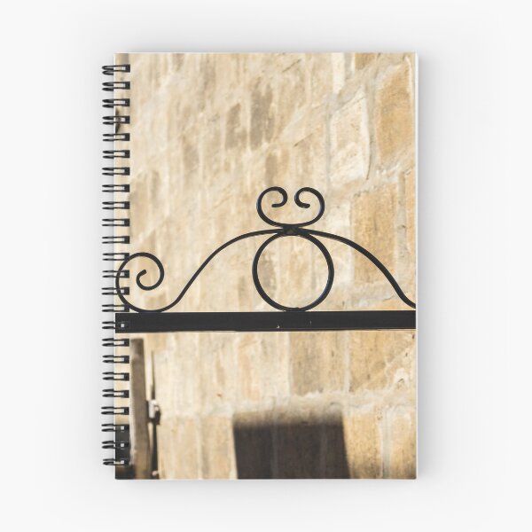 Item preview, Wrought Iron Decorative Gate Bracket With Scrollwork Against Sunlit Stone Wall in Historic Courtyard designed and sold by Nmallia.