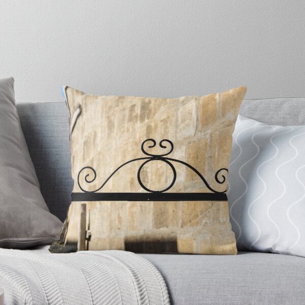 Item preview, Wrought Iron Decorative Gate Bracket With Scrollwork Against Sunlit Stone Wall in Historic Courtyard designed and sold by Nmallia.