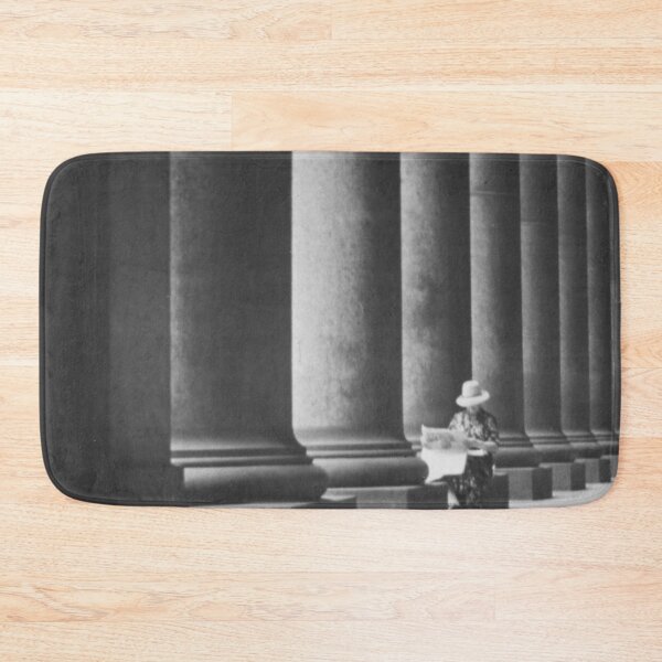 Item preview, Woman reading newspaper while seated beside building columns black and white vintage art print photograph designed and sold by Astrid Arkhangelsky.