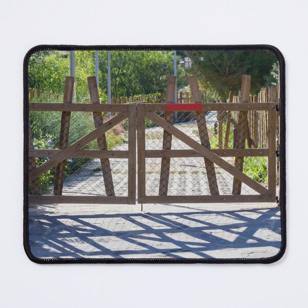 Item preview, Rustic Wooden Gate And Garden Fence Opening Onto Sunlit Path With Strong Shadow Patterns designed and sold by Nmallia.