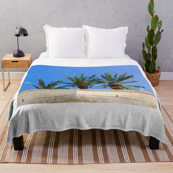 Item preview, Three Palm Trees Rising Above A Pale Stone Wall Under A Clear Blue Sky On A Sunny Day designed and sold by Nmallia.