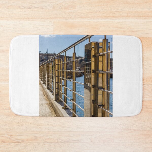 Item preview, Stainless Steel Railing Along Marina Waterfront Promenade With Blue Sea Reflections And Sunny Walkway designed and sold by Nmallia.