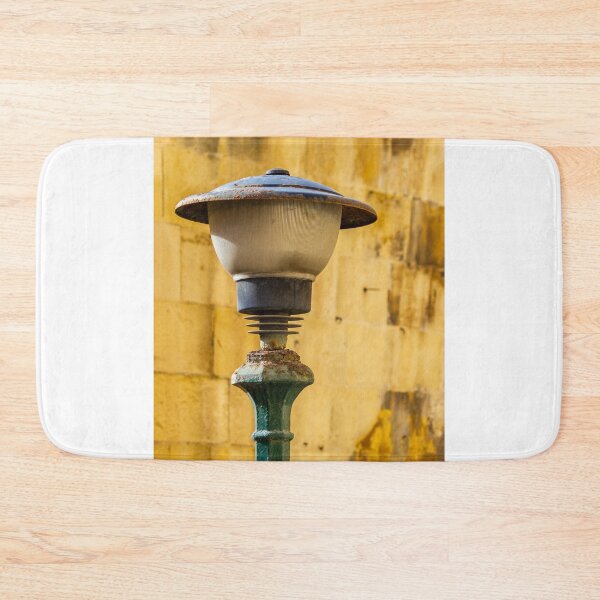 Item preview, Vintage Rusted Street Lamp Post Against Sunlit Yellow Stone Wall, Urban Texture and Decay designed and sold by Nmallia.