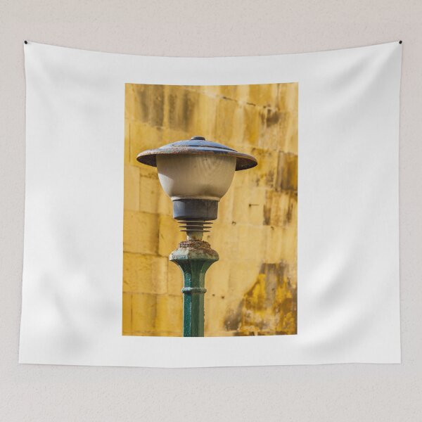 Item preview, Vintage Rusted Street Lamp Post Against Sunlit Yellow Stone Wall, Urban Texture and Decay designed and sold by Nmallia.