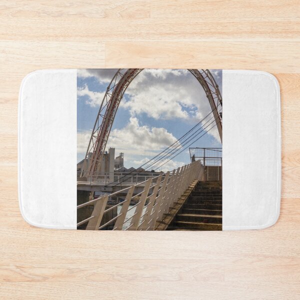 Item preview, Modern Arch Bridge With Stairs and Railing Over Harbor Water Under Dramatic Cloudy Sky designed and sold by Nmallia.