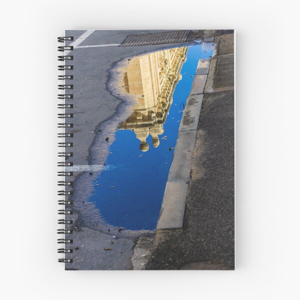 Item preview, Architectural Reflection in Puddle on Urban Street With Blue Sky and Historic Building Details designed and sold by Nmallia.
