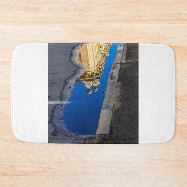 Item preview, Architectural Reflection in Puddle on Urban Street With Blue Sky and Historic Building Details designed and sold by Nmallia.