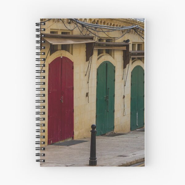 Item preview, Row Of Colorful Arched Wooden Doors On Stone Building Facade With Weathered Awnings designed and sold by Nmallia.