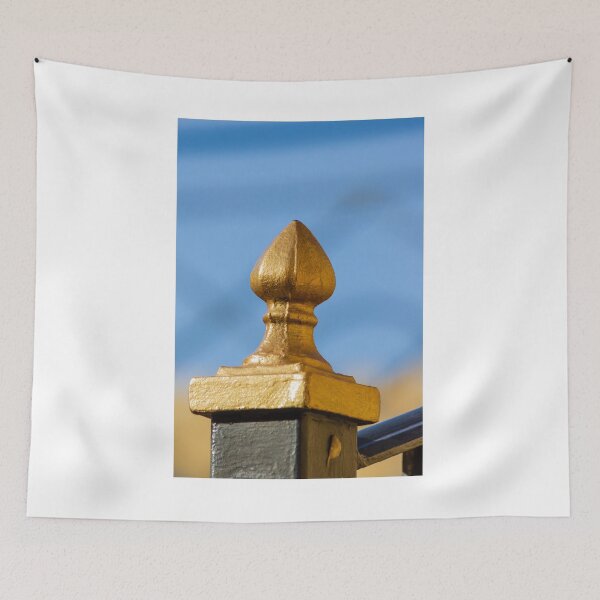 Item preview, Golden Finial Fence Post Close-Up Against Blue Sky – Gilded Decorative Metal Railing Detail designed and sold by Nmallia.