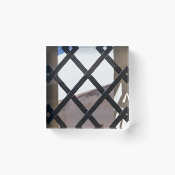 Item preview, Black Metal Lattice Fence With Diamond Pattern Framing Bright Urban Building And Blue Sky Background designed and sold by Nmallia.