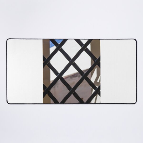 Item preview, Black Metal Lattice Fence With Diamond Pattern Framing Bright Urban Building And Blue Sky Background designed and sold by Nmallia.