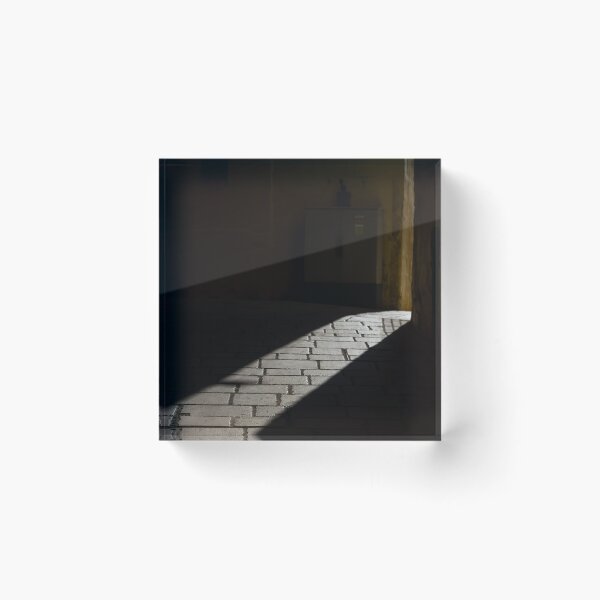 Item preview, Diagonal Sunlight on Cobblestone Alleyway Casting Dramatic Shadow in Narrow Urban Passage designed and sold by Nmallia.