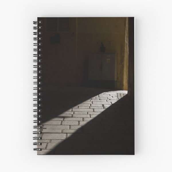 Item preview, Diagonal Sunlight on Cobblestone Alleyway Casting Dramatic Shadow in Narrow Urban Passage designed and sold by Nmallia.