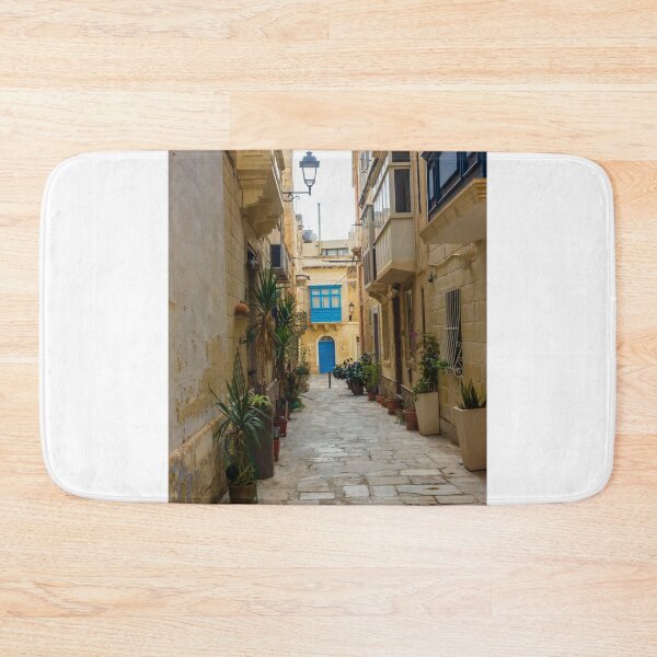 Item preview, Sunlit Narrow Mediterranean Alley With Blue Door, Stone Pavement, Potted Plants And Traditional Balconies designed and sold by Nmallia.