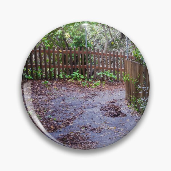 Item preview, Leaf-Covered Garden Path With Wooden Fence Curving Through Lush Greenery In Autumn designed and sold by Nmallia.